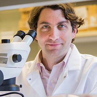 A researcher stand by laboratory equipment